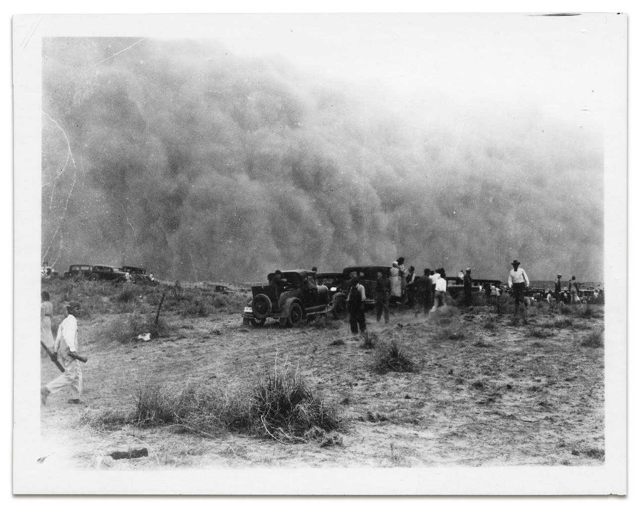 Изображение Фотография, на которой изображена вереница людей и машин недалеко от Тайрона, штат Канзас, готовящихся к надвигающейся пыльной буре в 1935 году 